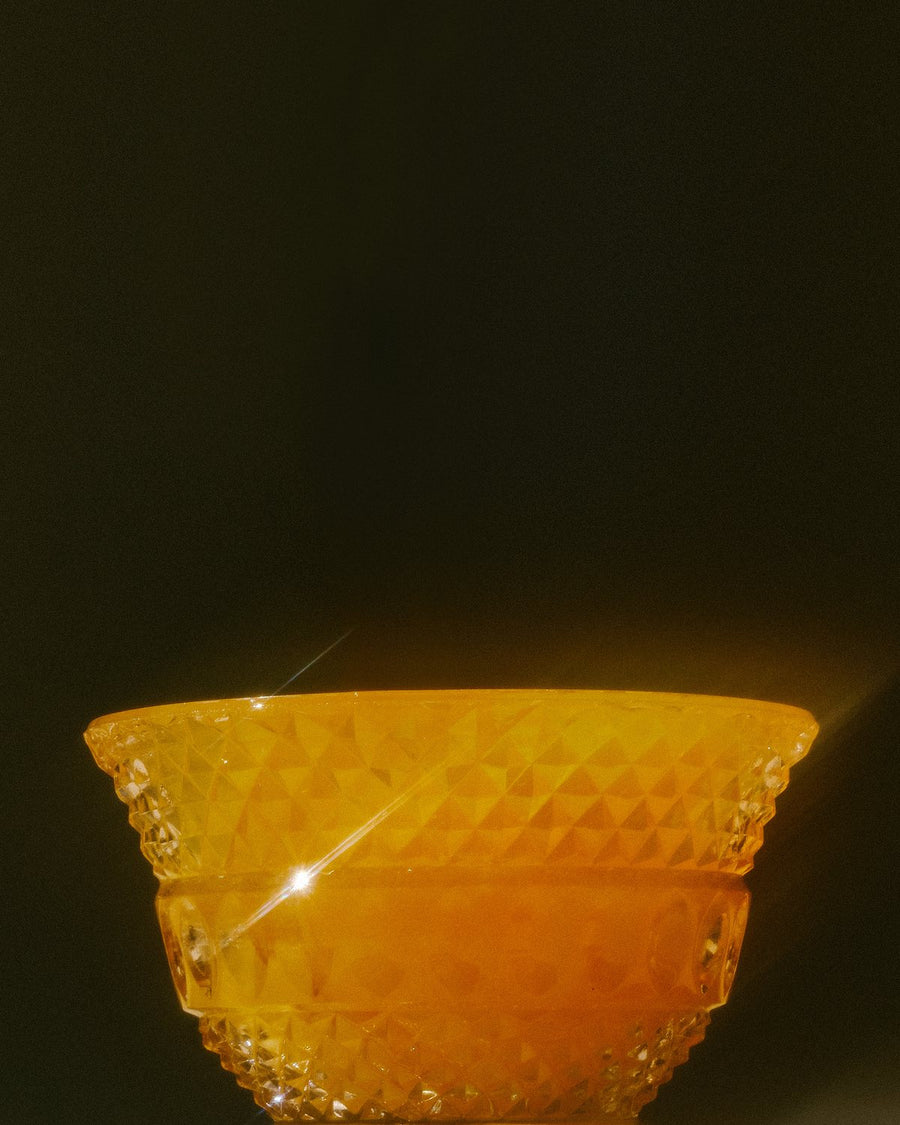A cut glass bowl glowing honey gold